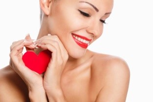 Smith Surgery-Woman with red lipstick holding a small red heart in her hands