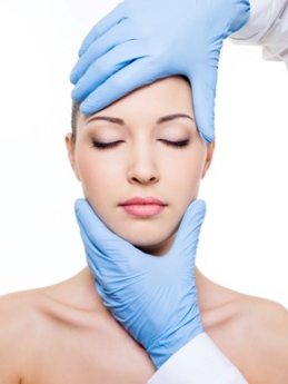 Smith Surgery-Plastic surgeon holding woman's face for facelift consultation
